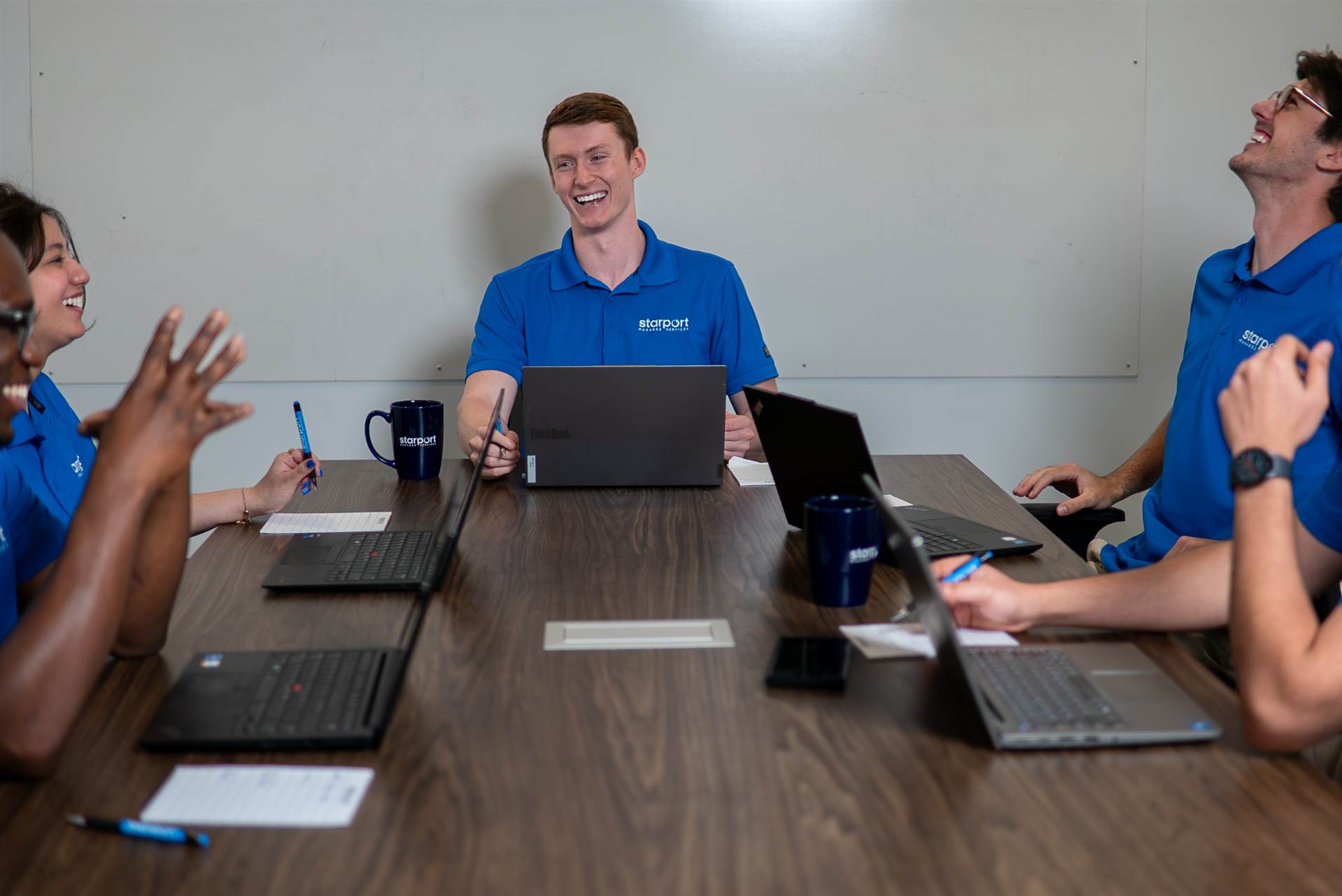 Corporate team laughing around a conference table during a meeting in PEI - Eastside Photography