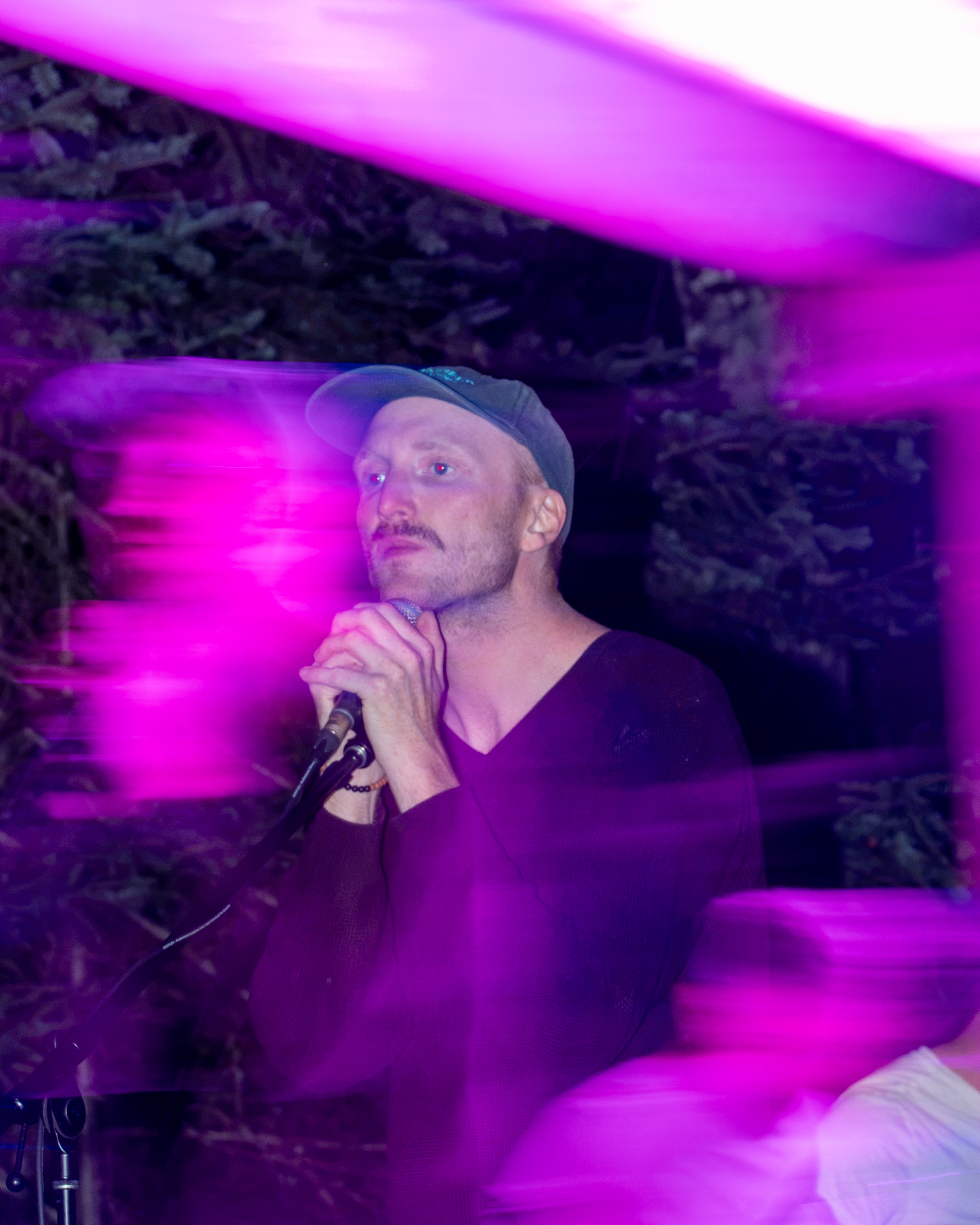 Live vocalist performing a passionate set on stage under deep purple concert lighting in PEI - Eastside Photography