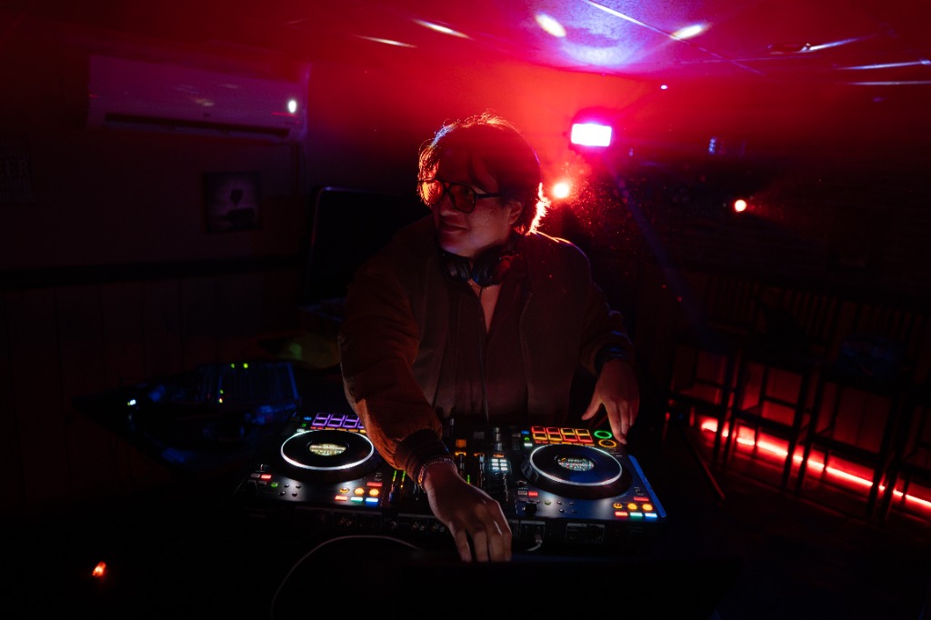DJ under high-intensity red spotlight at a Prince Edward Island nightlife event - Eastside Photography concert coverage