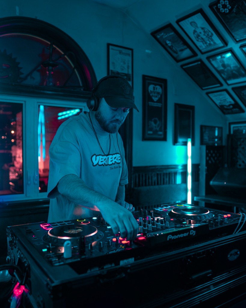 Moody DJ promo close-up mixing on decks under deep blue nightclub spot wash - Eastside Photography Charlottetown PEI