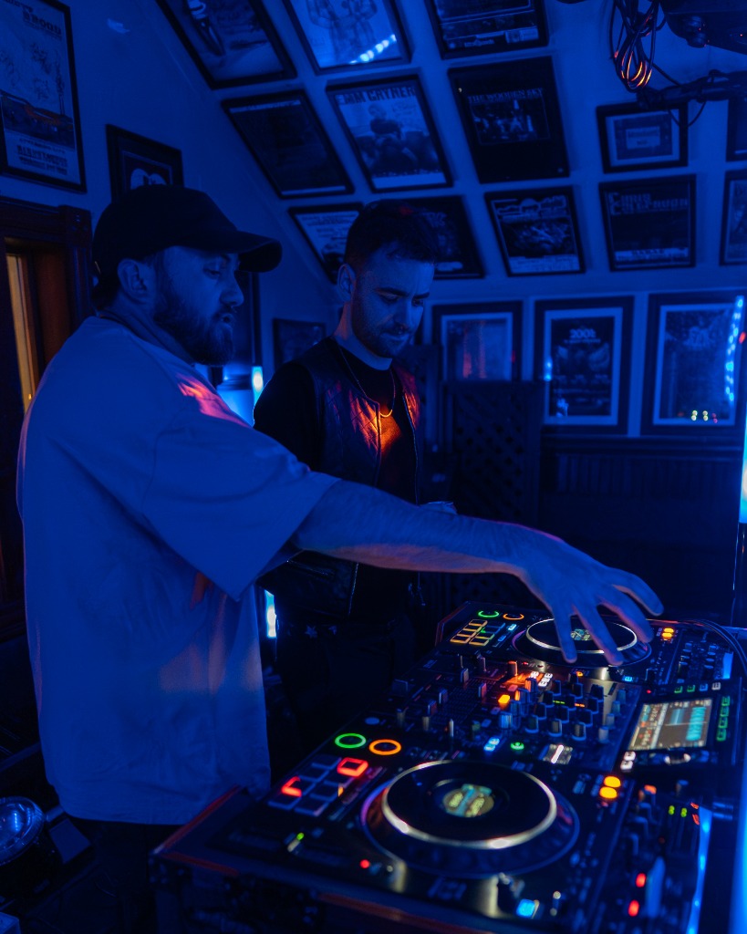 Collaborative DJ set with two artists mixing together under deep blue club spotlights - Eastside Photography behind the scenes PEI