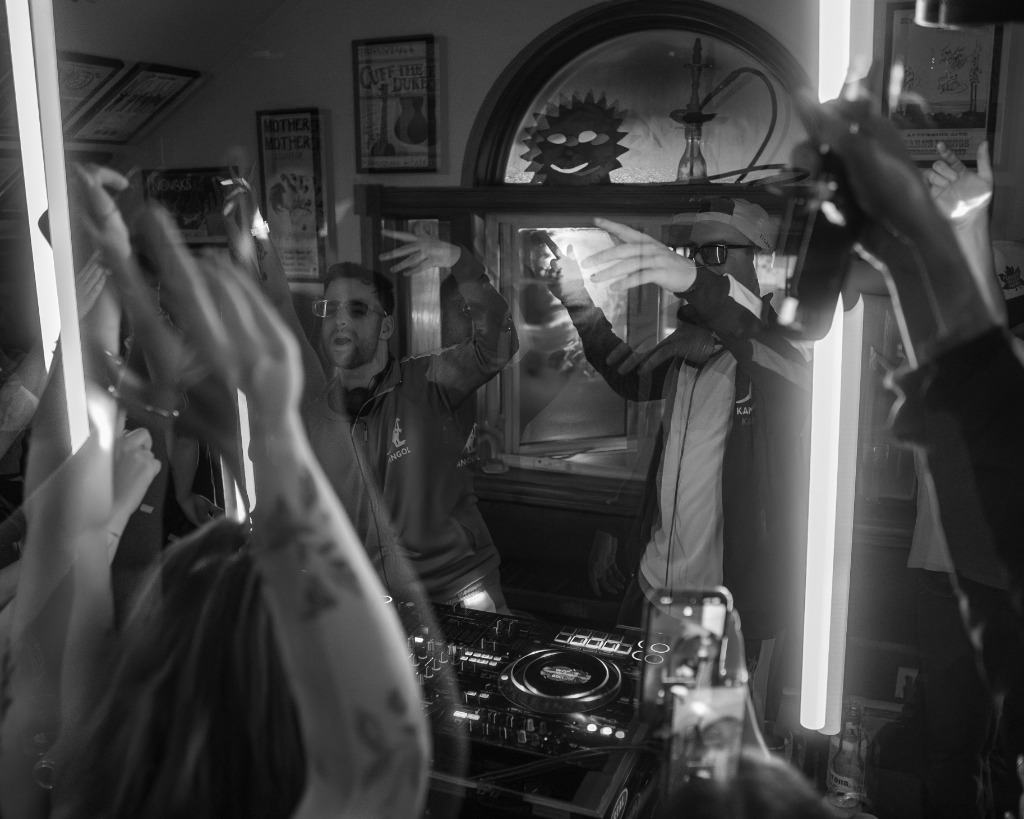 Black and white artistic crowd silhouette and DJ performing with neon tubes in Cavendish PEI - Eastside Photography