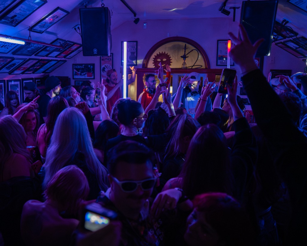 Vibrant music festival crowd dancing under red lasers and stage lights at a Cavendish PEI event - Eastside Photography