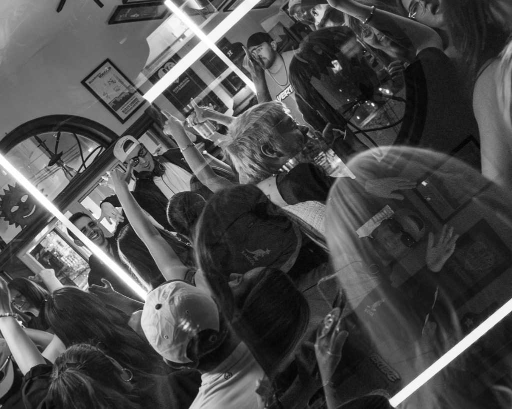 High-contrast black and white reflection of a packed dance floor and DJ deck in Charlottetown nightclub - Eastside Photography