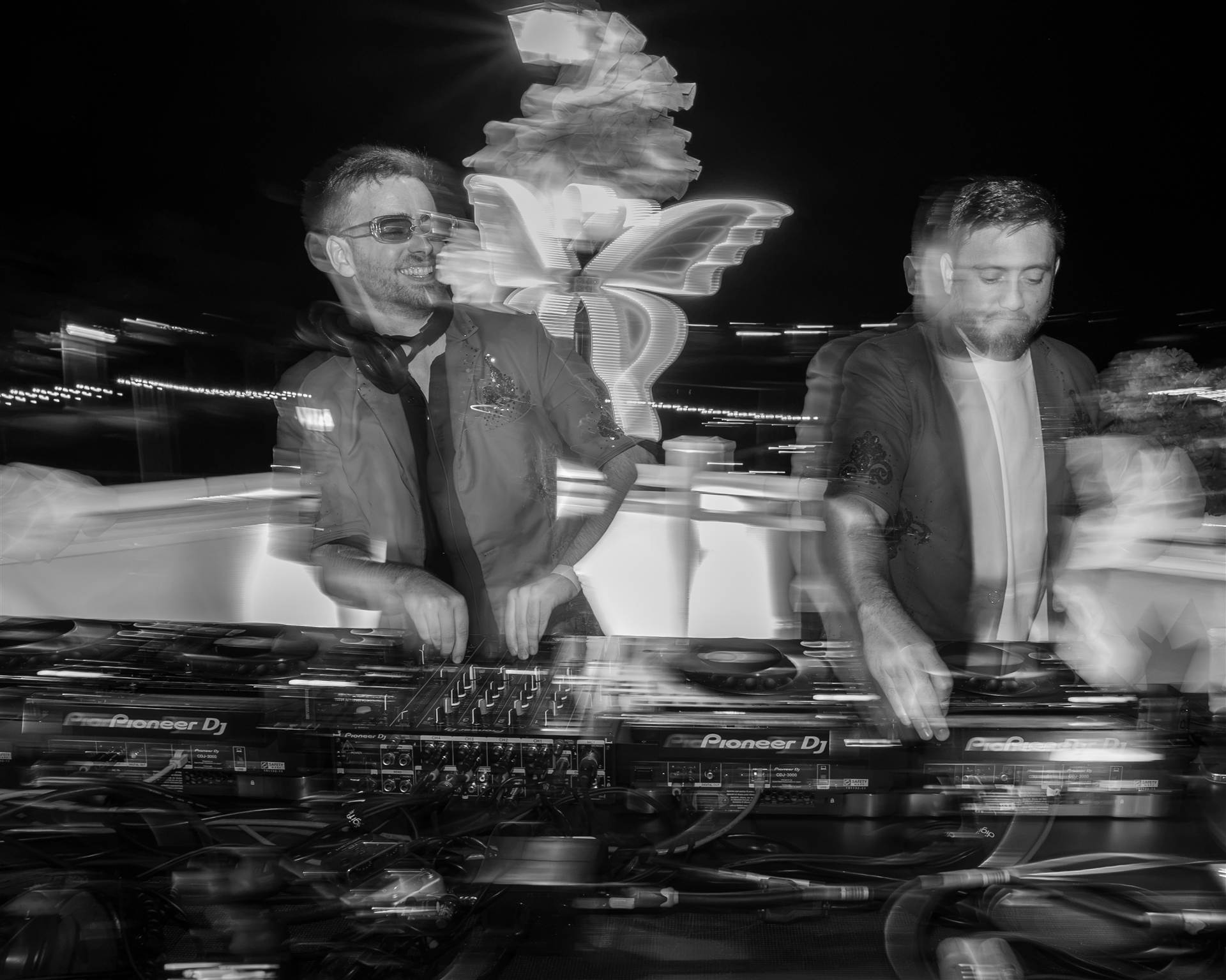 DJ outdoors at Pioneer with crowd hands raised black and white night Sundrift PEI - Eastside Photography